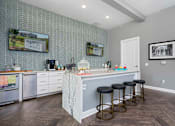 Thumbnail 7 of 30 - A kitchen with a bar area and stools.