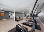 Thumbnail 21 of 28 - A gym with a variety of exercise equipment including treadmills, stationary bikes, and weights.