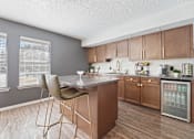 Thumbnail 2 of 28 - A kitchen with a table and chairs in front of a refrigerator.