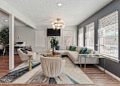 Thumbnail 1 of 28 - A living room with a white sofa, a coffee table, and a large window with blinds.