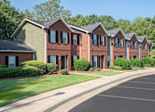 Thumbnail 17 of 67 - A row of red brick houses with green lawns in front.