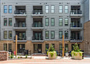 Thumbnail 37 of 45 - A building with balconies and plants in front.