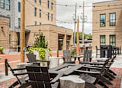 Thumbnail 35 of 45 - A row of black chairs are lined up on a brick patio.