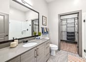 Thumbnail 17 of 43 - A bathroom with a toilet, sink, and mirror.