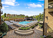 Thumbnail 25 of 43 - A pool surrounded by lounge chairs and umbrellas.