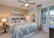 Thumbnail 11 of 37 - A bedroom with a large bed and a ceiling fan.