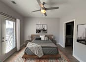 Thumbnail 16 of 36 - A bedroom with a bed, a ceiling fan, and a rug.