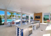 Thumbnail 41 of 78 - a kitchen with a bar and a view of a pool at Altis Blue Lake, Lake Worth, Florida