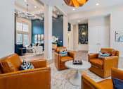 Thumbnail 15 of 35 - A living room with brown leather chairs and a white coffee table.