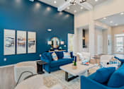 Thumbnail 18 of 35 - A living room with blue couches and a white coffee table.