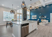 Thumbnail 21 of 35 - A modern kitchen with a large island and stainless steel appliances.