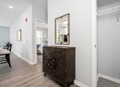 Thumbnail 13 of 35 - A brown wooden chest of drawers with a mirror on top is in a room with white walls.
