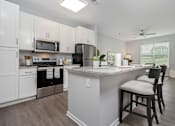Thumbnail 1 of 35 - A kitchen with a white island and black bar stools.