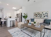 Thumbnail 6 of 35 - A modern living room with a kitchen in the background.