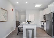 Thumbnail 5 of 35 - A kitchen with a white island and stainless steel appliances.