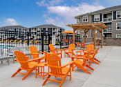 Thumbnail 30 of 35 - A patio with orange chairs and a wooden pergola.