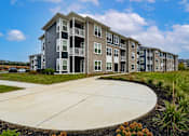 Thumbnail 33 of 35 - A large apartment complex with a circular driveway in front.