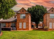 Thumbnail 2 of 69 - a red brick house with a green lawn and a cloudy sky