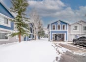 Thumbnail 33 of 43 - a car parked in front of some blue houses covered in snow