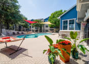 Thumbnail 26 of 31 - a swimming pool with patio furniture and umbrellas