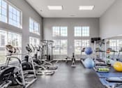 Thumbnail 20 of 31 - A gym with a variety of exercise equipment and a large window.