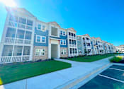 Thumbnail 19 of 23 - A row of modern apartment buildings with balconies and green lawns.
