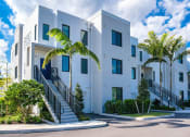 Thumbnail 2 of 78 - a building with stairs and palm trees in front of it at Altis Blue Lake, Lake Worth, 33467