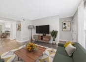 Thumbnail 15 of 35 - a living room with a couch and a coffee table and a television