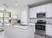Thumbnail 1 of 36 - a kitchen with white cabinets and stainless steel appliances