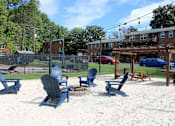 Thumbnail 17 of 24 - Beach chairs and picnic tables are arranged on a sandy beach.