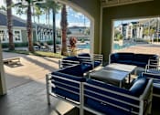 Thumbnail 19 of 31 - A patio with blue chairs and a table is shown.