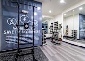 Thumbnail 13 of 27 - A gym with a sign that says "Restore" and a wall with a sign that says "Workout Save the Environment".