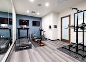Thumbnail 14 of 27 - A spacious gym with treadmills, exercise bikes, and a weight machine.