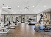 Thumbnail 18 of 29 - A spacious gym with a variety of equipment including treadmills, weights, and a stationary bike.