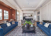 Thumbnail 11 of 16 - A living room with a dark brown coffee table and blue couches.