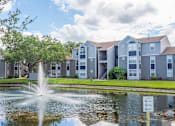 Thumbnail 25 of 25 - a fountain in the pond with an apartment building in the background