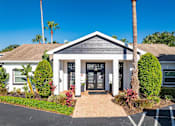 Thumbnail 4 of 10 - A house with a grey roof and white walls has a black front door.