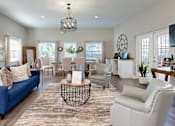 Thumbnail 5 of 10 - A living room with a blue sofa and white chairs.