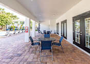 Thumbnail 6 of 10 - A patio with a table and chairs is shown.