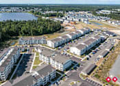 Thumbnail 22 of 23 - A bird's eye view of a residential complex with multiple buildings and a parking lot.