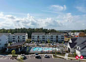 Thumbnail 23 of 23 - A large white building with a pool in front of it.
