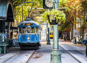 Thumbnail 7 of 7 - a blue trolley train traveling down a city street