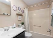 Thumbnail 12 of 23 - A bathroom with a white sink, toilet, and bathtub.
