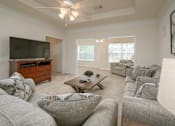 Thumbnail 16 of 43 - A living room with a grey couch and a wooden coffee table.