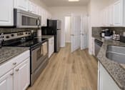 Thumbnail 6 of 43 - A kitchen with black appliances and white cabinets.