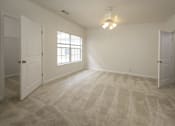 Thumbnail 22 of 43 - A room with a carpeted floor and a window letting in natural light.