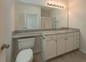 Thumbnail 19 of 43 - A bathroom with a toilet, sink, and mirror.