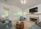Thumbnail 12 of 43 - A living room with a fireplace and a television mounted above it.