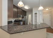 Thumbnail 32 of 32 - A kitchen with a granite countertop and white cabinets.