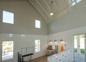 Thumbnail 10 of 67 - A room with a white ceiling and walls, a window, a table, and a bench.